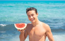 Young fit body boy portrait holding red fresh watermelon...
