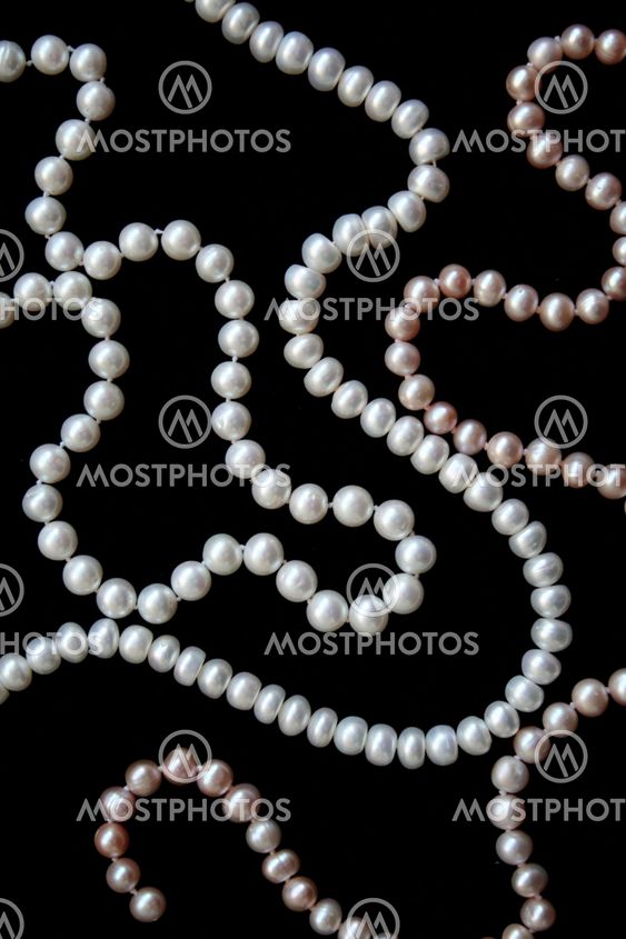 White and pink pearls on the black silk
