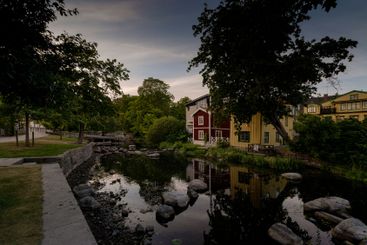 River, trees, and houses during sunset