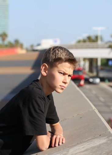 Handsome teenager standing with skateboard. Adolescent...