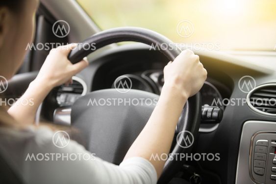 Close-up of female hands on the steering wheel