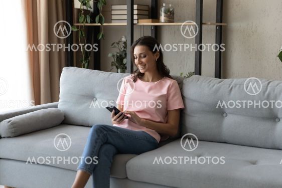 Smiling Arabian woman using smartphone, having fun,...