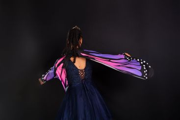 Brunette teen girl wearing butterfly wings and making...