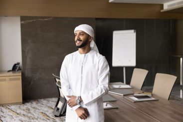 Confident businessman dressed in traditional dishdasha...