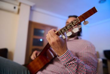 Person Playing an Acoustic Guitar Indoors Showcasing...