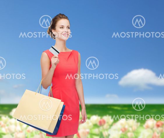 smiling woman with shopping bags and plastic card