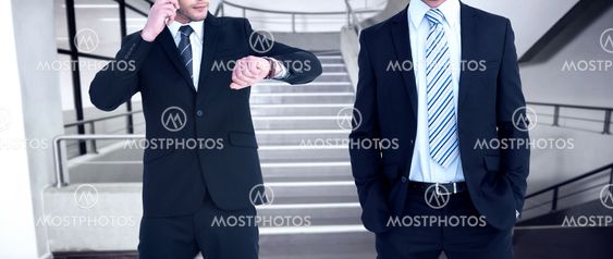 Composite image of smiling elegant businessman with hands in pockets