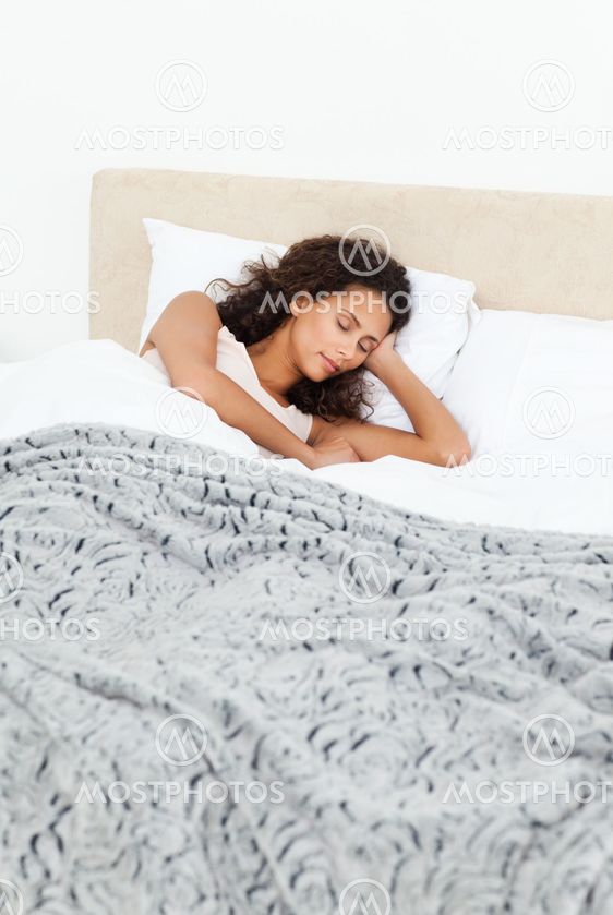 Beautiful woman sleeping peacefully on her bed in the morning