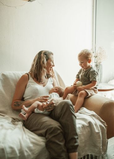 Love, bonding and mom with her toddler and baby relaxing...