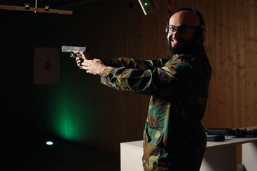 Portrait of happy soldier in firing range preparing for...