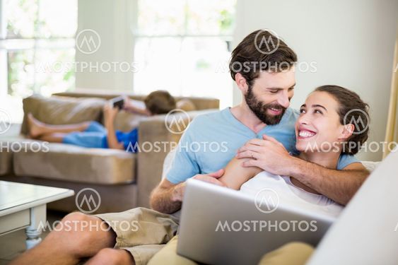 Happy young couple embracing on sofa
