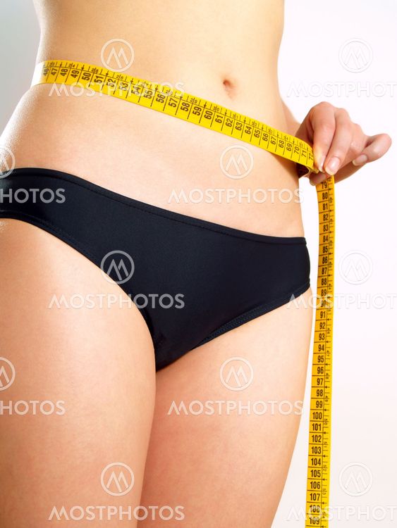 Girl measuring her abdomen after diet