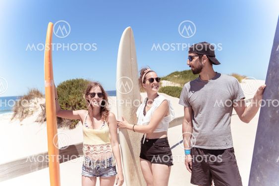 Boys and girls teen surfers with surfboards