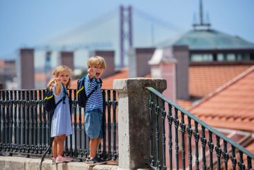 Young travelers stand at Lisbon viewpoint point with...