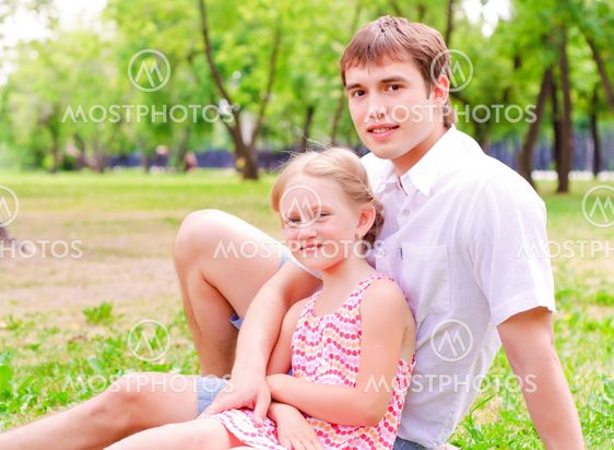 Father and daughter sitting together on the grass