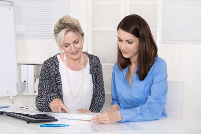 Two attractive businesswoman in meeting analyzing budget.