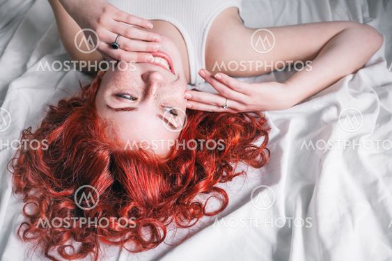 Portrait of young beautiful woman with long hair lying in...