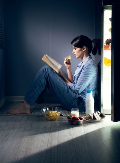 Sleepless woman reading in the kitchen