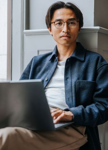 Portrait of male business professional sitting with...