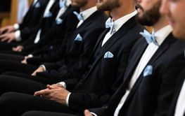 Guests sit on benches during a wedding in the Catholic...