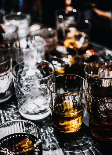 Whiskey Cocktail with Ice Sphere in a Moody Bar Setting