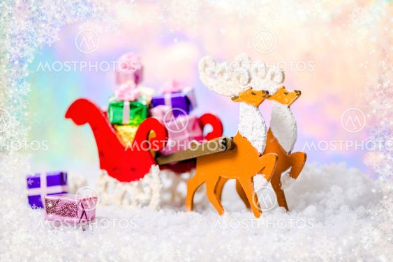 Christmas decoration reindeer and Santa sleigh with gifts in snow on north polar light background, closeup