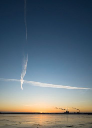 Criss-crossing contrails on background of blue evening sky 