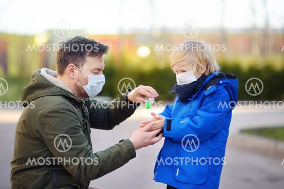 Mature man and little child wearing a protective mask...