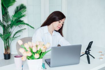 woman brunette sitting at table chatting online business