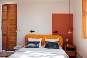 A modern bedroom with a comfortable bed and a bright...