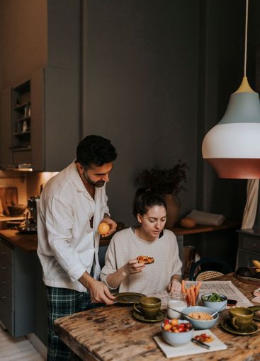 Couple reading newspaper while having breakfast at home