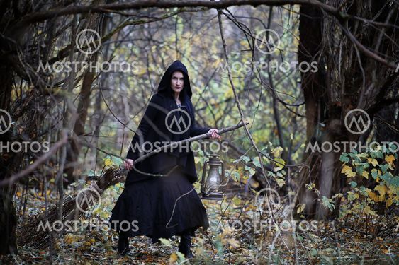 A woman in a witch suit in a forest