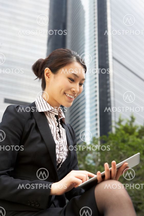 Chinese Businesswoman Working On Tablet Computer Outside Office