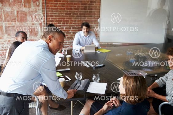 Businesspeople Meeting In Modern Boardroom Through Glass