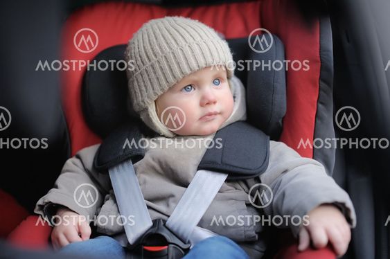 Toddler boy sitting in car seat