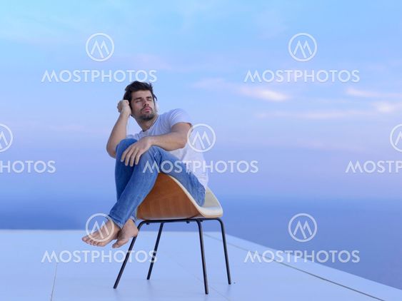 relaxed young man at home on balcony