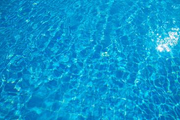 Crystal clear blue water reflecting sunlight in a serene...