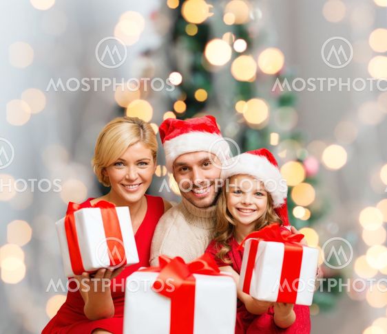 happy family in santa helper hats with gift boxes
