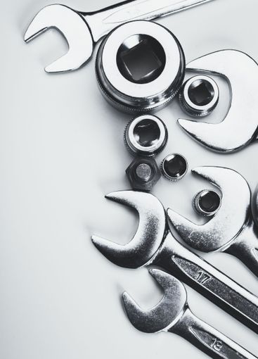 Collection of shiny metallic tools arranged on a light...