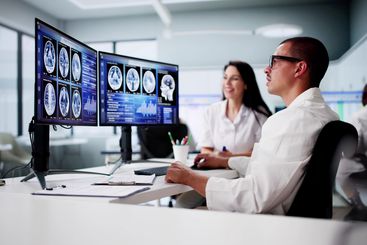 Doctors In Clinic Looking At Brain MRI Scan