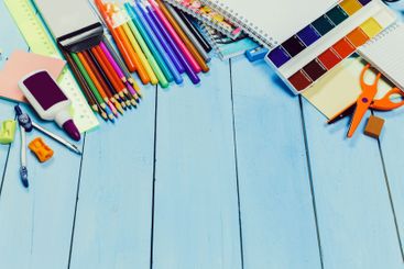 Colorful assortment of art supplies arranged on a blue...