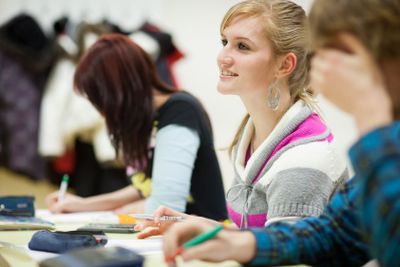 pretty, female college student sitting in a classroom...