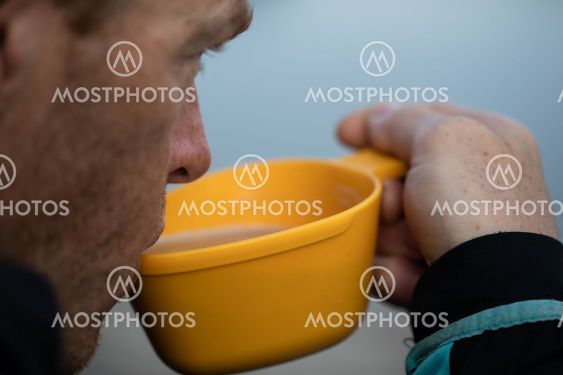 man dricker kaffe ur kåsa
