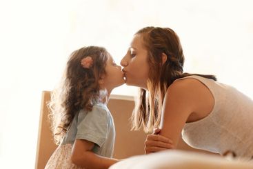 Child, love and woman with kiss in home for motherhood,...