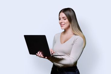 Young smiling woman using laptop on white studio background