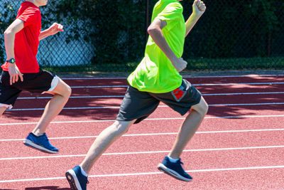Two young boys running fast on a track