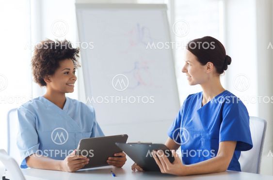 happy doctors with tablet pc meeting at hospital