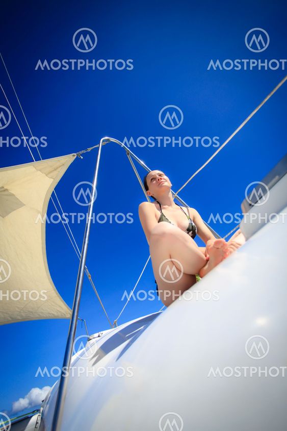 Young caucasian woman sitting in front of a boat