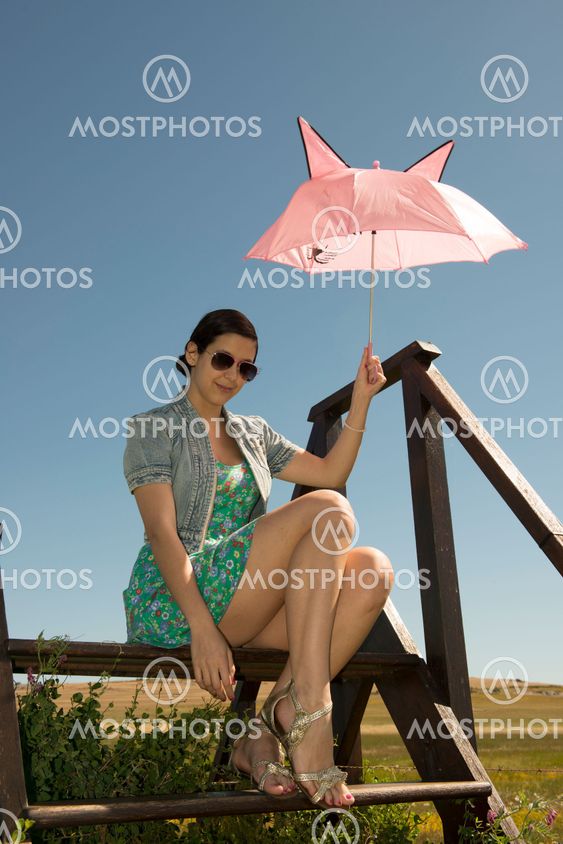 Beautiful adult smelling flowers on sunny field enjoying herself