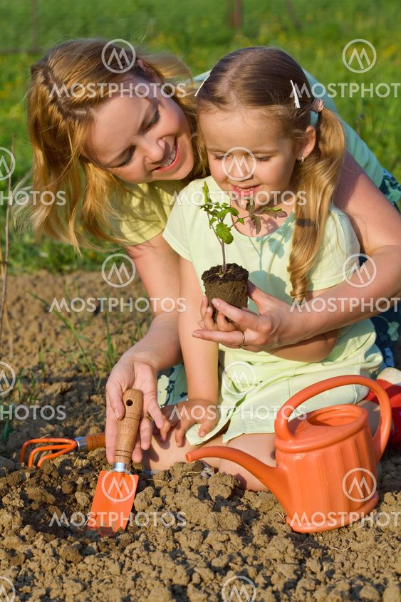 Woman and little girl growing healthy food
